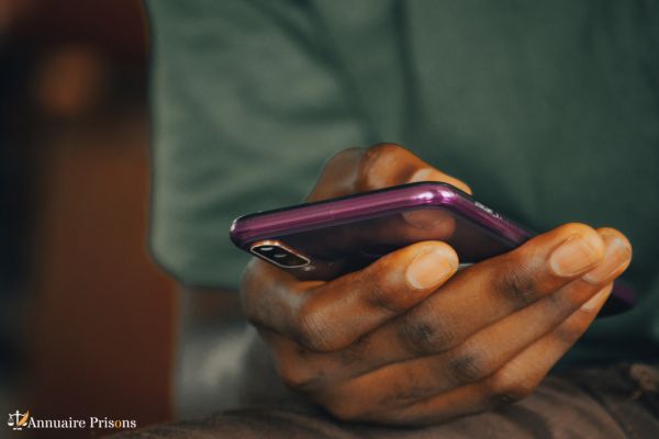 homme détenu devant son téléphone portable