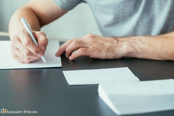 prisonnier écrivant une lettre en cellule