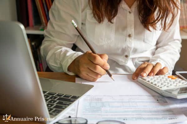 femme calculant les frais d'incarcération de son mari prisonnier